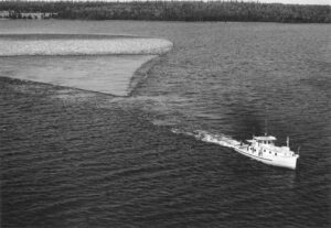 Aerial View of Boat Pulling Boom in 1961