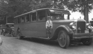 A Young Boy on the Running Board of a Bus From the 1920's