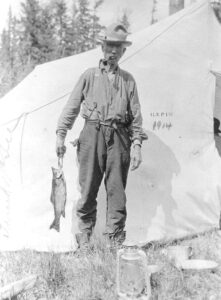 Man Holding a Fish at Camp in 1914