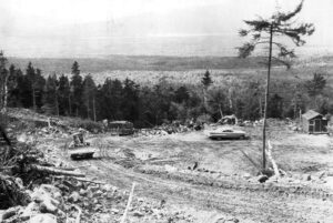 Late 1950's Car in a Clear Cut with a Skidder