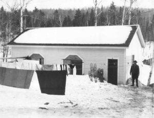 Man Hanging Laundry in the Winter at a Ripogenus Dam Building