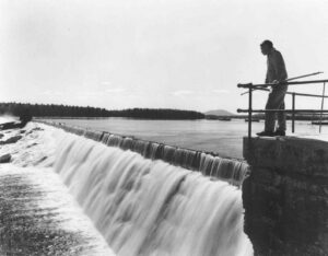 Stone Dam Spilling with a Man Watching