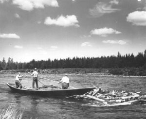 Three Men Poling Wood From a Boat