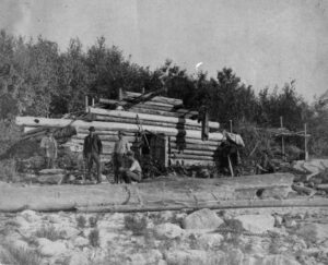 Men Standing at an Old Boom House