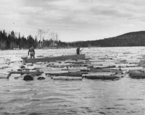 Two Men Working Pulp on the Lake in a Boat